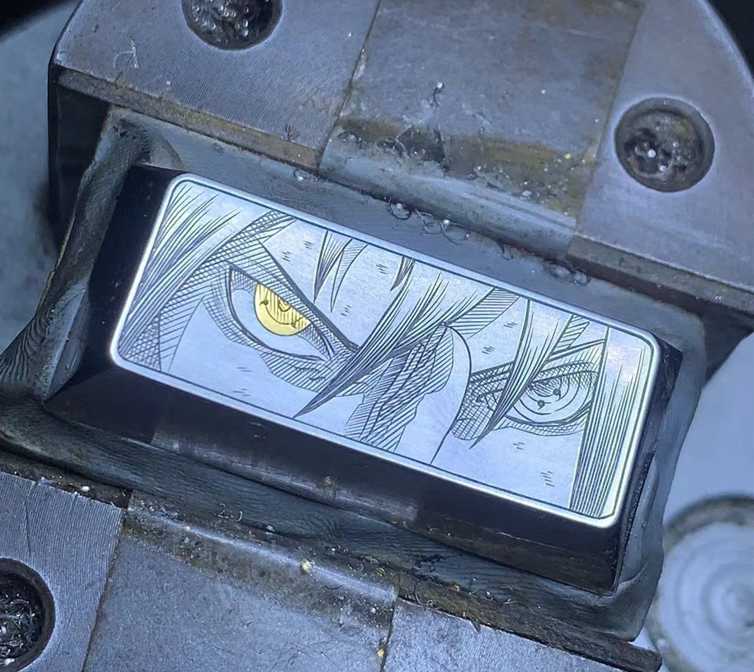 Hand carved Uchiha Sasuke Sharingan in titanium alloy, with gold inlaid eyes. Keycap